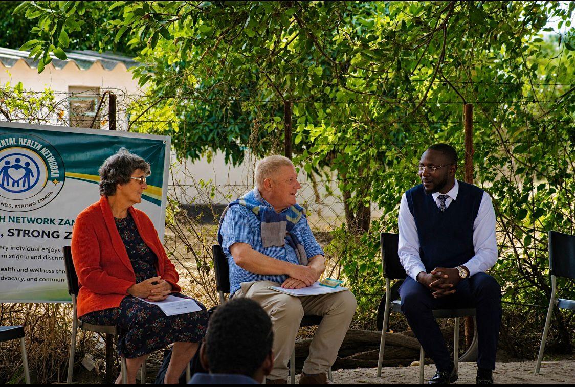 Patrick Mwewa on an outdoor panel with Mr. and Mrs. Waddell in Mwandi